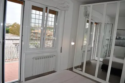 a room with white walls and windows and a bedroom at Alloggio Turistico Roberta San Pietro in Rome