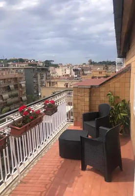 a balcony with chairs and a view of a city at Alloggio Turistico Roberta San Pietro in Rome