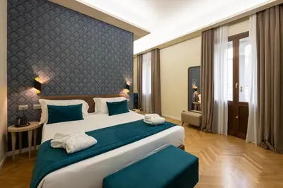 a bedroom with a large bed with a blue wall at Hotel Caravita in Rome
