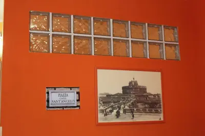 an orange wall with a picture and a sign on it at Aracoeli in Rome