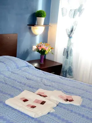 two towels on a bed with a vase of flowers at Aracoeli in Rome