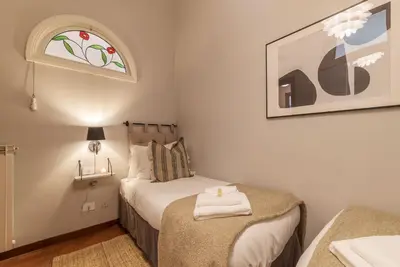 a small bedroom with a bed and a window at Lively Roma Trastevere renovated apartment - FromHometoRome in Rome