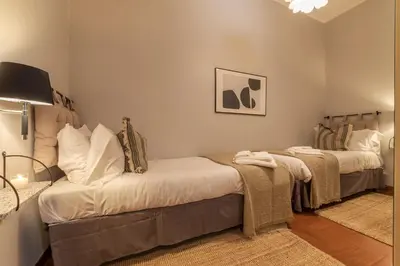 a bedroom with two beds and a tv on the wall at Lively Roma Trastevere renovated apartment - FromHometoRome in Rome