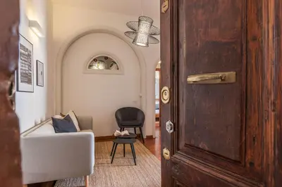 an open door to a living room with a chair at Lively Roma Trastevere renovated apartment - FromHometoRome in Rome