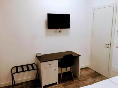 a room with a desk and a television on a wall at Pigneto Guest House in Rome