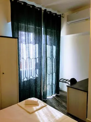 a bedroom with a bed and a window with curtains at Pigneto Guest House in Rome