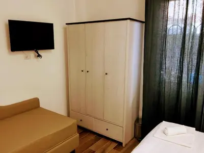 a bedroom with a bed and a cabinet with a television at Pigneto Guest House in Rome