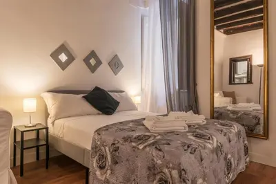 a bedroom with a bed and a large mirror at GuestHost - Fori Imperiali Apartment in Rome