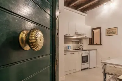 a kitchen with a green door and a kitchen with a table at GuestHost - Fori Imperiali Apartment in Rome
