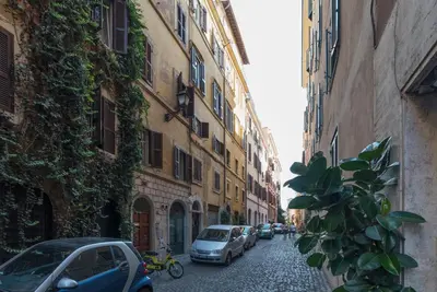 a narrow street with cars parked on the side of buildings at GuestHost - Fori Imperiali Apartment in Rome
