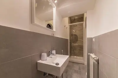 a bathroom with a sink and a mirror at GuestHost - Fori Imperiali Apartment in Rome