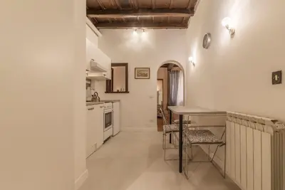 a kitchen with white walls and a table and chairs at GuestHost - Fori Imperiali Apartment in Rome