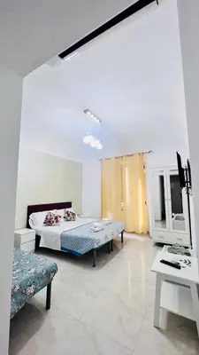 a white room with a bed and a table at ABID'S PALACE IN TERMINI in Rome