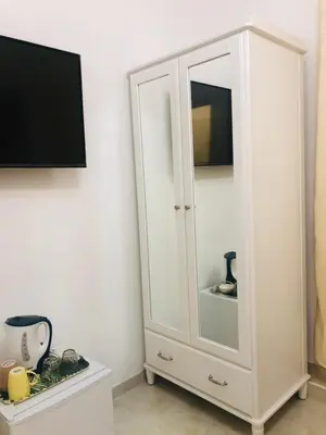 a white cabinet with a mirror and a tv at ABID'S PALACE IN TERMINI in Rome