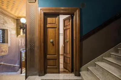 an open wooden door in a hallway with stairs at Flat Two in Rome