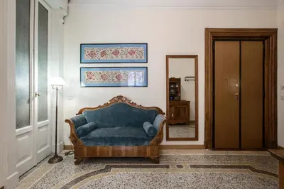 a living room with a blue couch and a mirror at Flat Two in Rome
