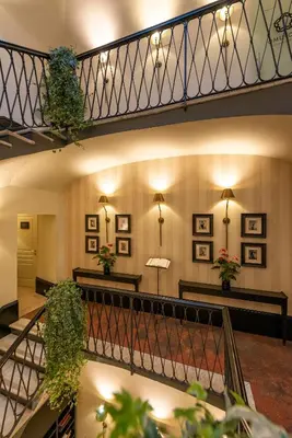 a lobby with a staircase with plants on the walls at Profumo Maison Colosseo in Rome