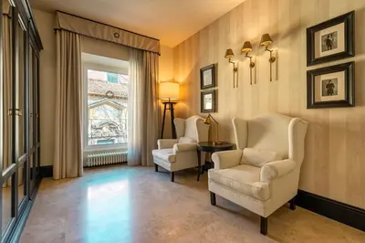 a living room with two chairs and a window at Profumo Maison Colosseo in Rome