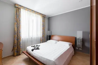 a bedroom with a bed and a large window at Crosti Apartments in Rome
