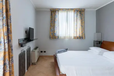 a bedroom with a bed and a television and curtains at Crosti Apartments in Rome