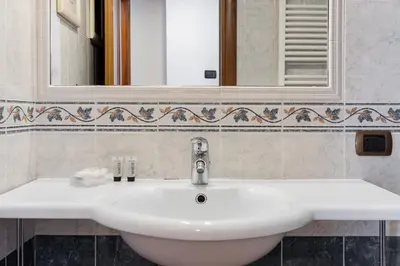 a white sink in a bathroom with a mirror at Crosti Apartments in Rome