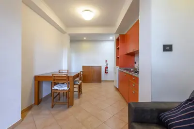 a living room with a table and a kitchen at Crosti Apartments in Rome