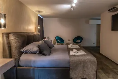 a bedroom with a bed and two blue chairs at Black And White Suite in Rome