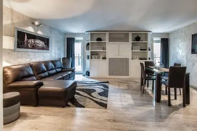 a living room with a leather couch and a table at Black And White Suite in Rome
