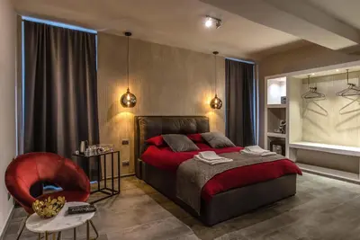 a bedroom with a red bed and a red chair at Black And White Suite in Rome