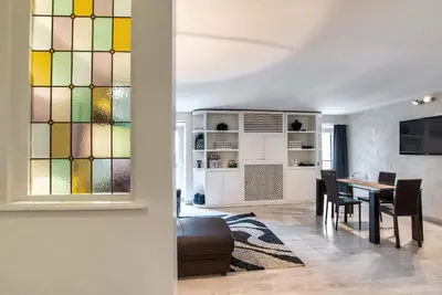 a living room with a table and a stained glass window at Black And White Suite in Rome