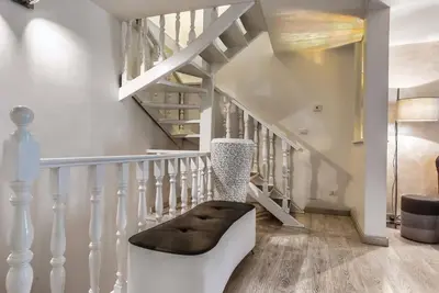 a white staircase with a bench next to a stair case at Black And White Suite in Rome