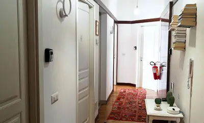 a hallway with white walls and a red rug at Tata B&B in Rome