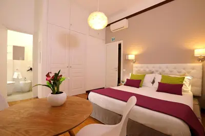 a bedroom with a bed and a table and a bathroom at Tata B&B in Rome