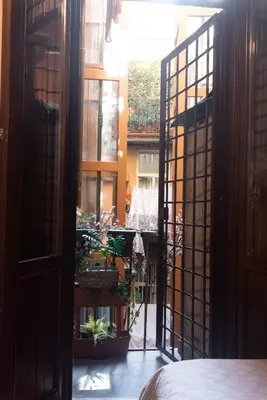 an open door to a courtyard with potted plants at Suite Michelangelo in Rome