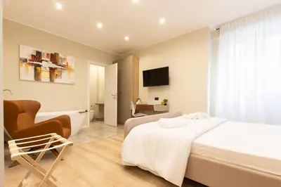 a bedroom with a bed and a chair and a television at Prati 25.7 Suites in Rome in Rome