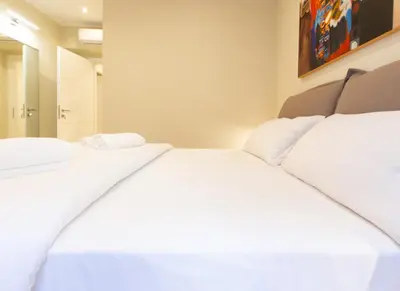 two beds in a room with white sheets at Prati 25.7 Suites in Rome in Rome
