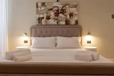 a bedroom with a bed with a painting on the wall at Prati 25.7 Suites in Rome in Rome