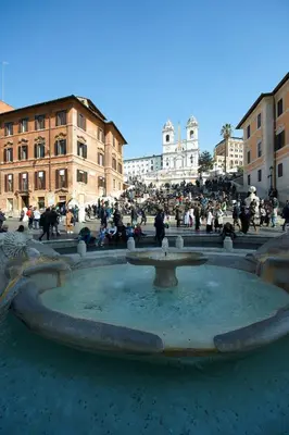 a group of people sitting around a fountain at Harry's Bar Trevi Luxury Apartments - Mignanelli in Rome