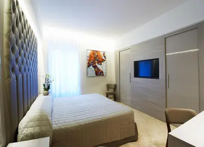a bedroom with a bed and a flat screen tv at Harry's Bar Trevi Luxury Apartments - Mignanelli in Rome