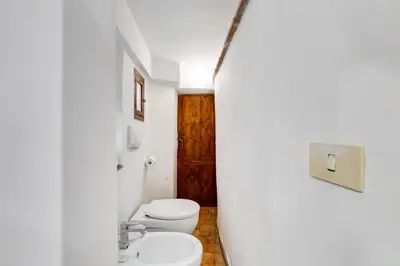 a white bathroom with a toilet and a sink at LIVING COLOSSEUM in Rome