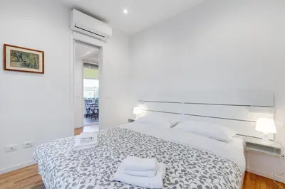a white bedroom with a large bed and a window at Giulio Cesare Apartment in Rome