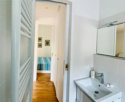 a white bathroom with a sink and a mirror at Giulio Cesare Apartment in Rome