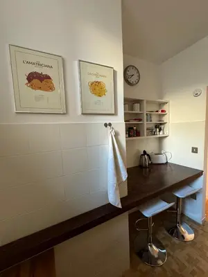 a kitchen with a counter and a clock on the wall at la casa di Romolo in Rome