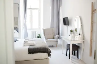 a white bedroom with a bed and a desk and a mirror at White Fanti Apartment in Rome