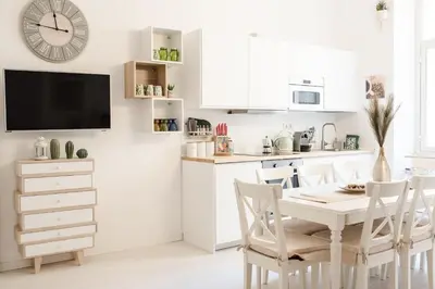 a kitchen with a table and chairs and a clock on the wall at White Fanti Apartment in Rome