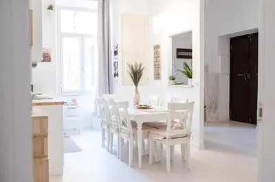 a white dining room with a white table and chairs at White Fanti Apartment in Rome