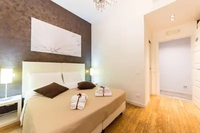 a bedroom with a large bed with two bags on it at Residenza Alexander Guest House in Rome