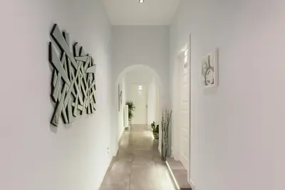 a hallway with a white wall with a black and white artwork at Residenza Alexander Guest House in Rome