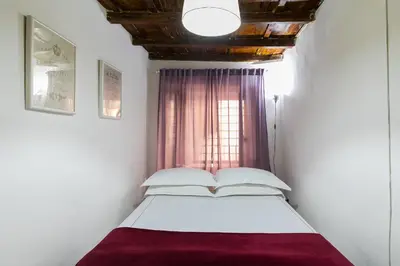 a bed in a room with a window at Moro 50 - Loft in Trastevere in Rome