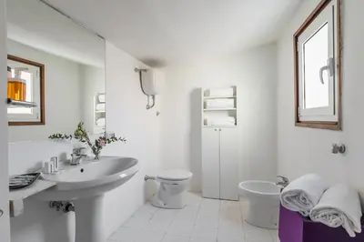 a white bathroom with a sink and a toilet at Moro 50 - Loft in Trastevere in Rome